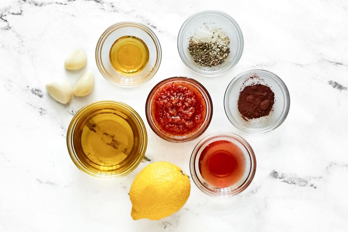 Harissa, honey, oil, lemon, vinegar, garlic, and seasonings.