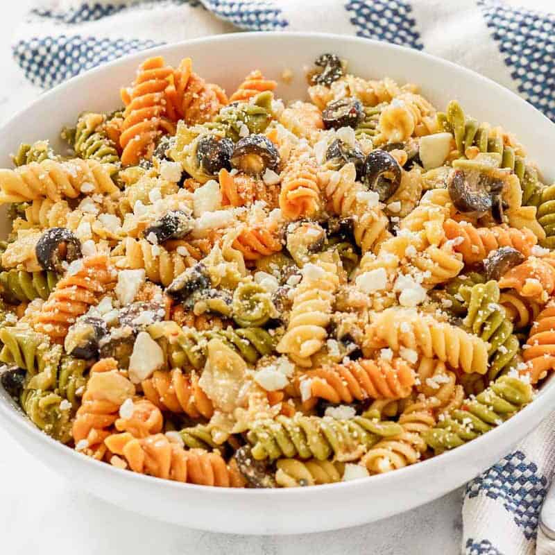 A bowl of olive and artichoke pasta salad.