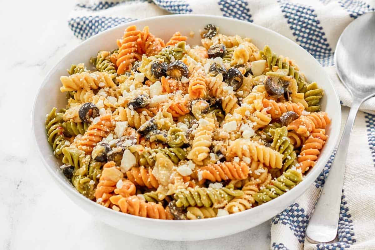 A bowl of olive and artichoke pasta salad.