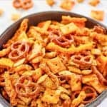 Homemade cheddar Chex mix with cheese crackers, cheese puffs, and pretzels.