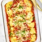 Cheese manicotti in marinara sauce baked with cheese on top.