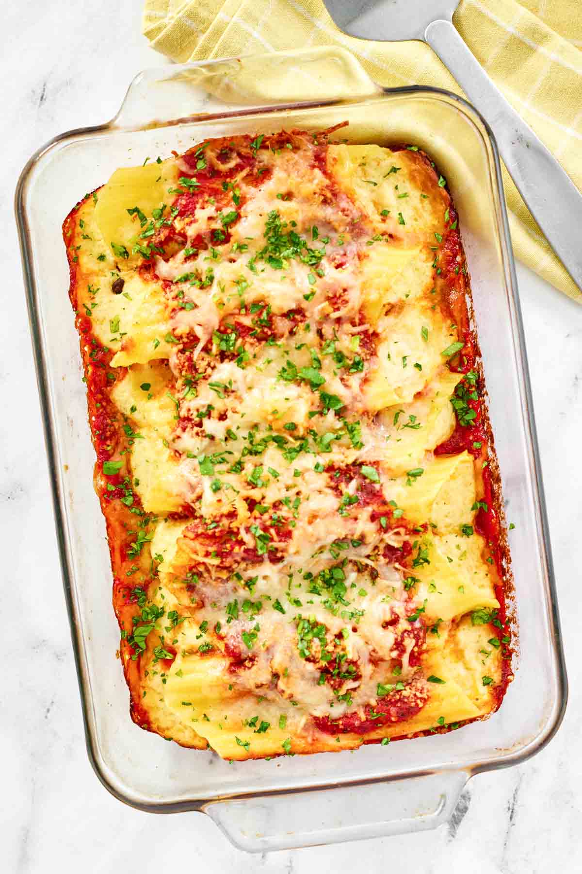 Cheese manicotti in marinara sauce baked with cheese on top.