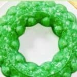 A creamy lime Jell-O salad with pineapple and cottage cheese made in a round mold.