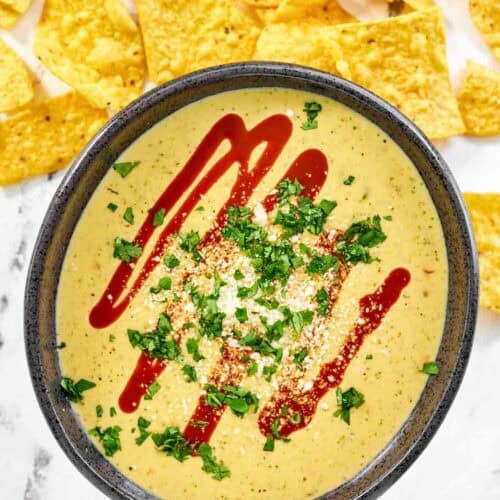Green chile and tomatillo cheese dip served over guacamole.