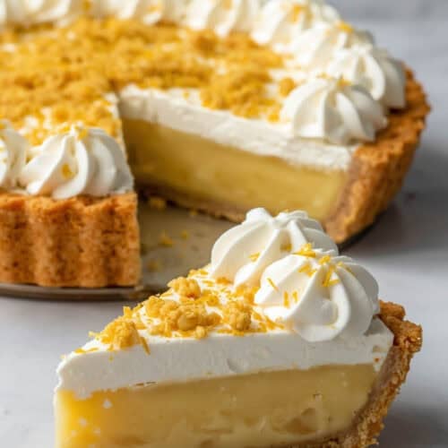Lemon ice box pie with cake crust topped with whipped cream and cake crumbles.