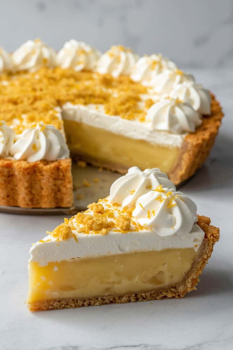 Lemon ice box pie with cake crust topped with whipped cream and cake crumbles.