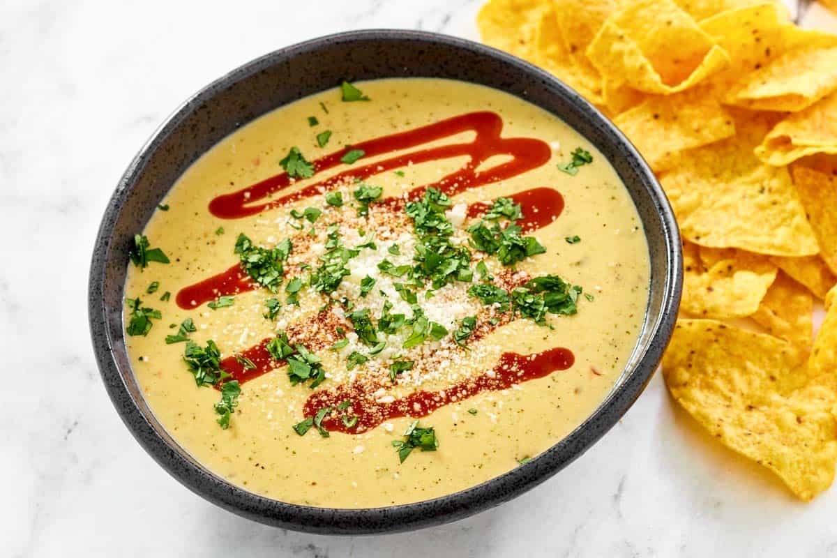 Spicy green chile queso served with tortilla chips.