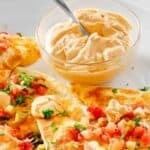 Copycat Taco Bell quesadilla sauce in a small bowl on a plate with quesadillas.