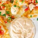 A small bowl of copycat Taco Bell quesadilla sauce next to quesadillas.