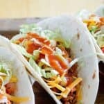A ground beef soft taco with copycat Taco Bell taco sauce on it.