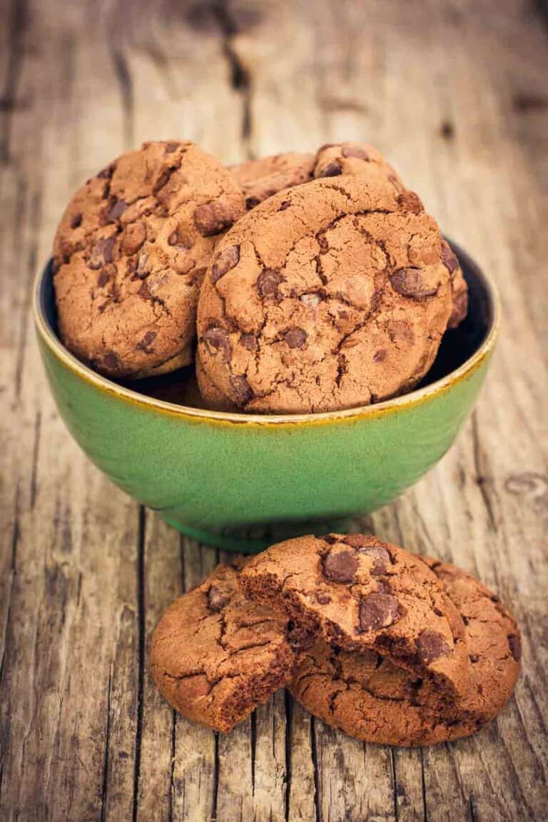 Chocolate chocolate chip cookies in a bowl and in front of it.