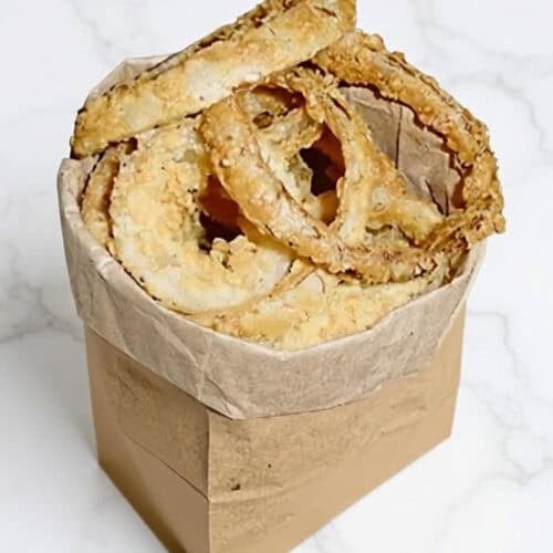Fried onion rings in a paper bag.