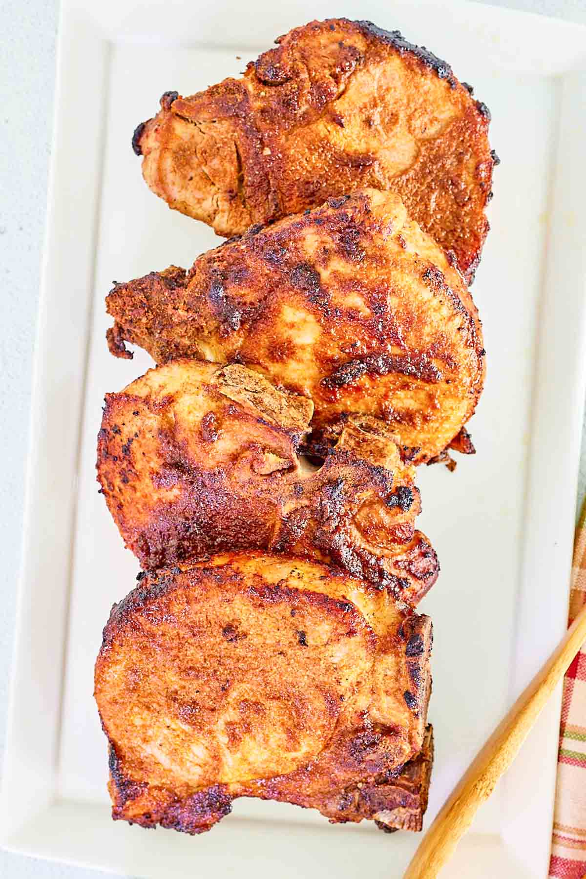 Bone-in thick-cut seasoned air-fried pork chops on a platter.