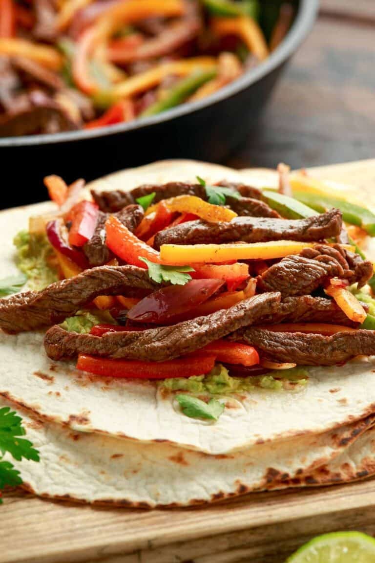 Steak fajitas on top of tortillas.