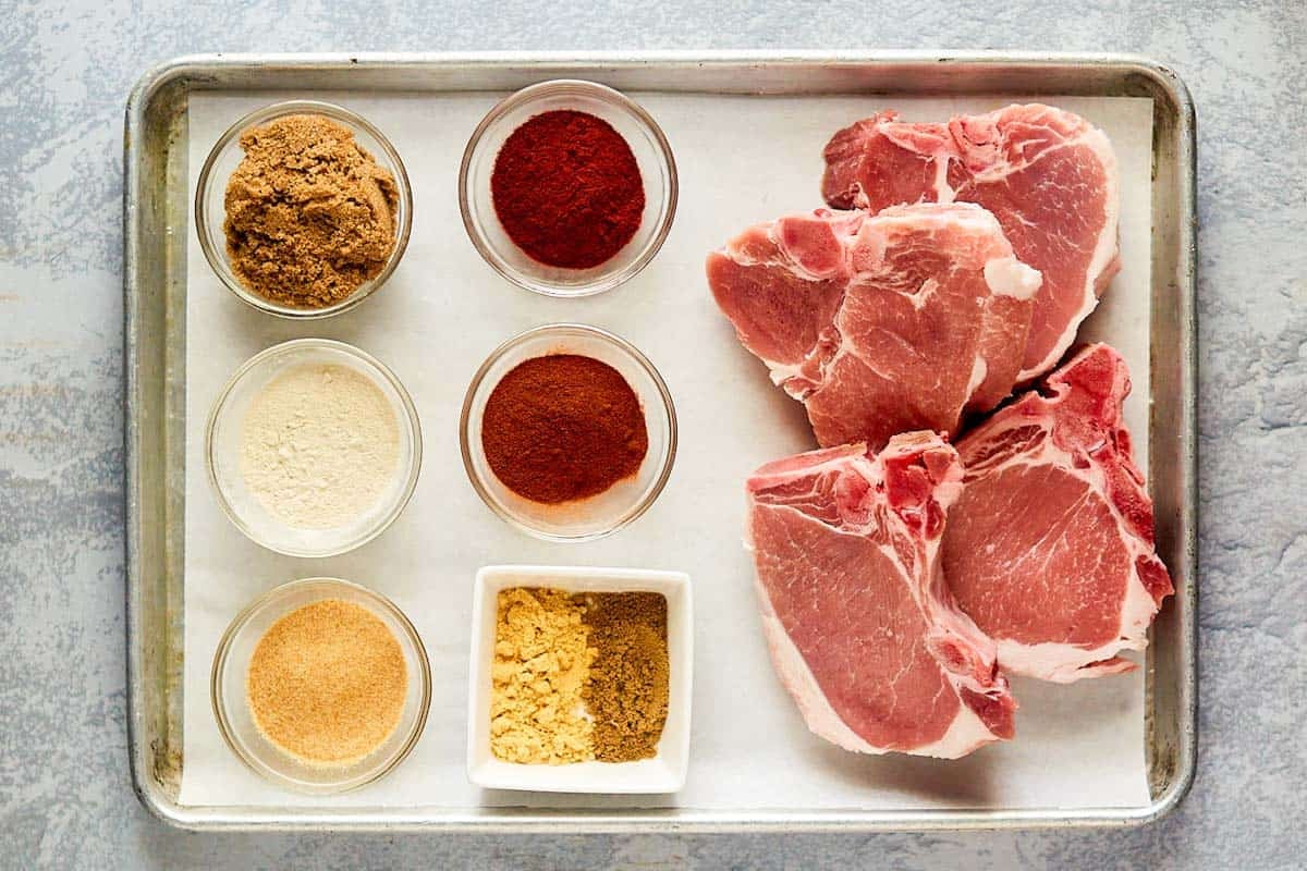 Bone-in pork chops and various seasonings.
