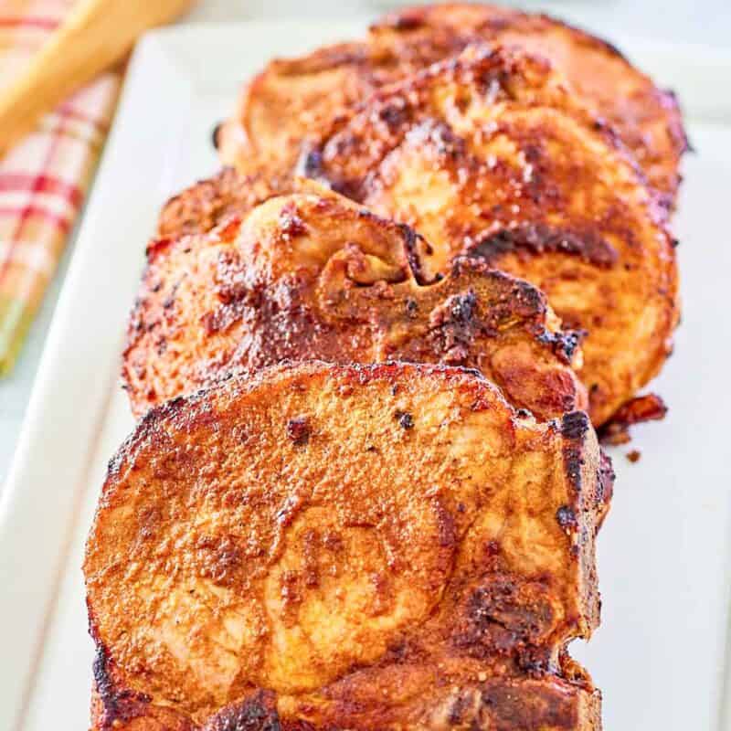 A platter of seasoned and cooked bone-in pork chops.