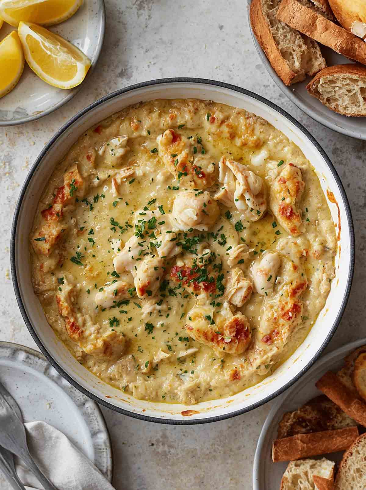 Hot crab dip, lemon slices, sliced bread.