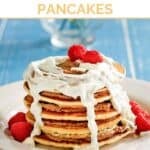 A stack of pancakes with cinnamon roll filling and cream cheese icing.
