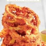 Copycat Red Robin onion rings stacked on a plate.