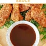 A small bowl of copycat TGI Friday's Jack Daniel's sauce on a plate with chicken tenders.