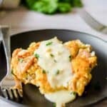 A serving of tarragon chicken popover casserole topped with sauce on a plate.