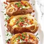 Copycat Texas Roadhouse baked potatoes loaded with toppings.