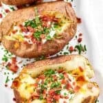 Loaded copycat Texas Roadhouse baked potatoes on a plate.