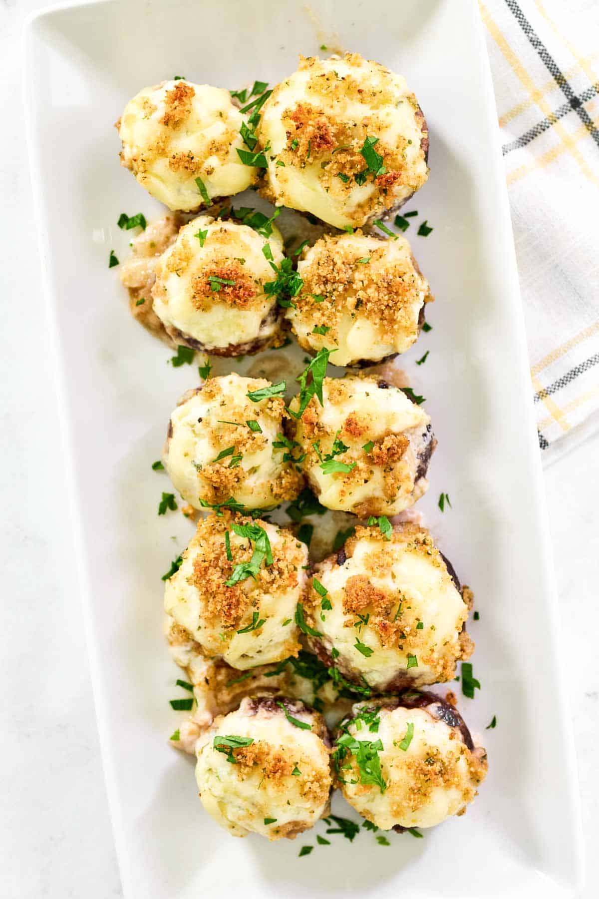 Cheesy stuffed mushrooms on a platter.