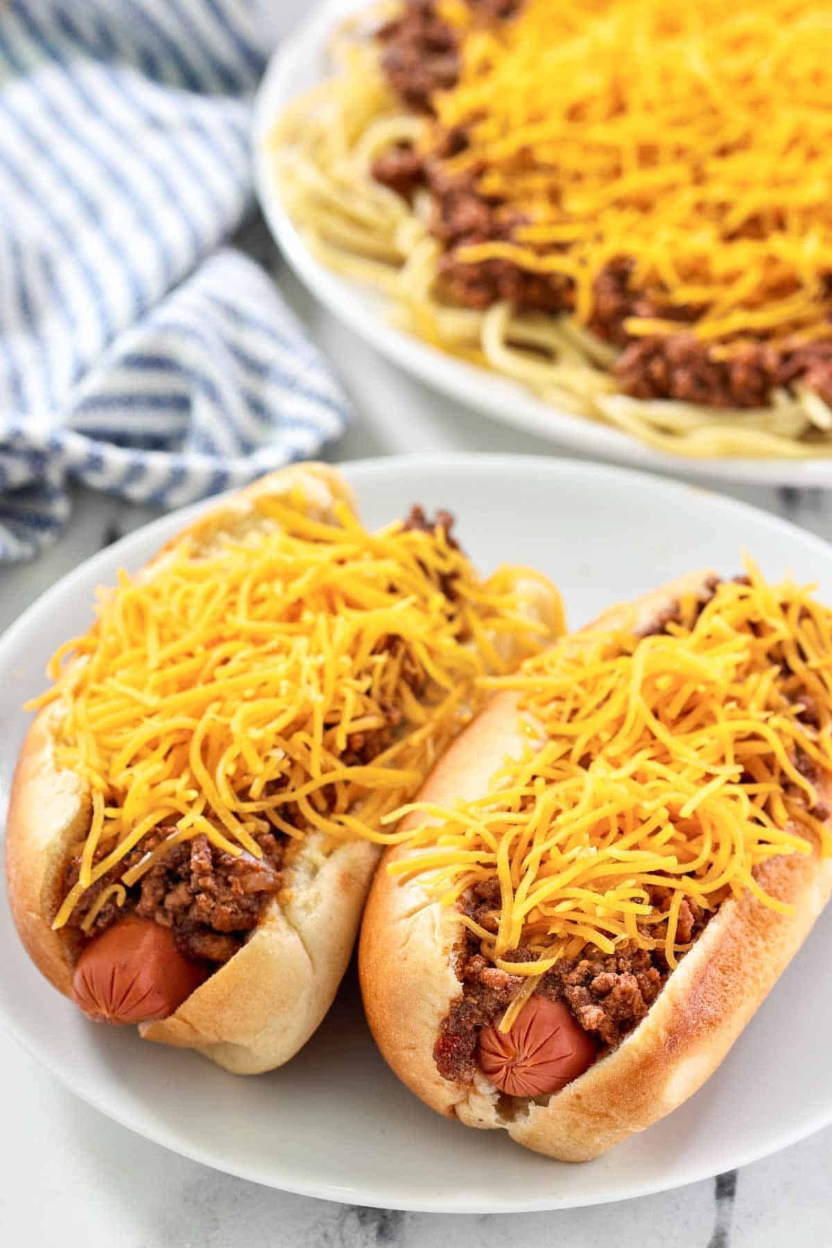 Chili cheese hot dogs and a plate of spaghetti with chili and cheese.