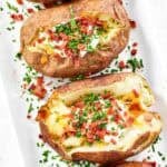 Loaded baked potatoes on a platter.