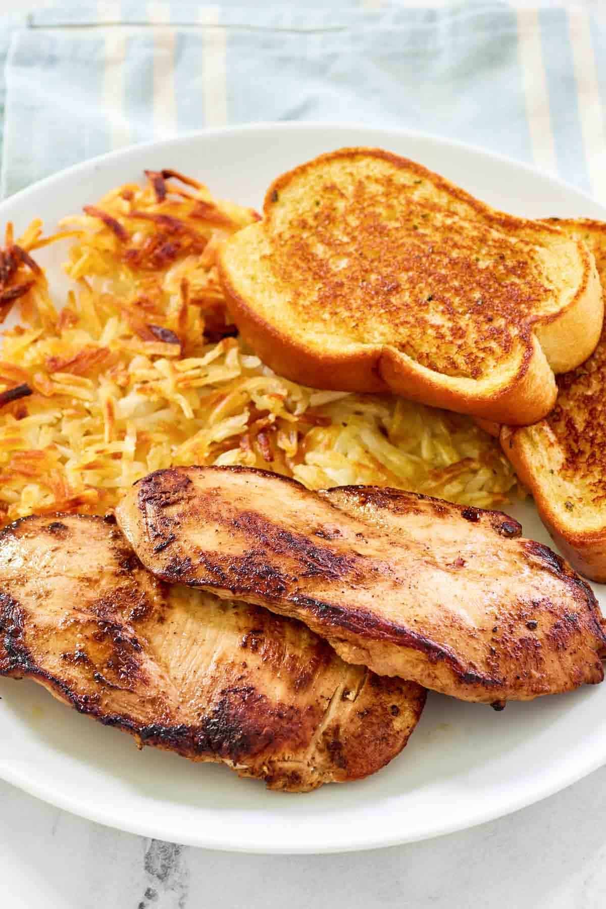 Marinated and grilled chicken served with hashbrowns and toast.