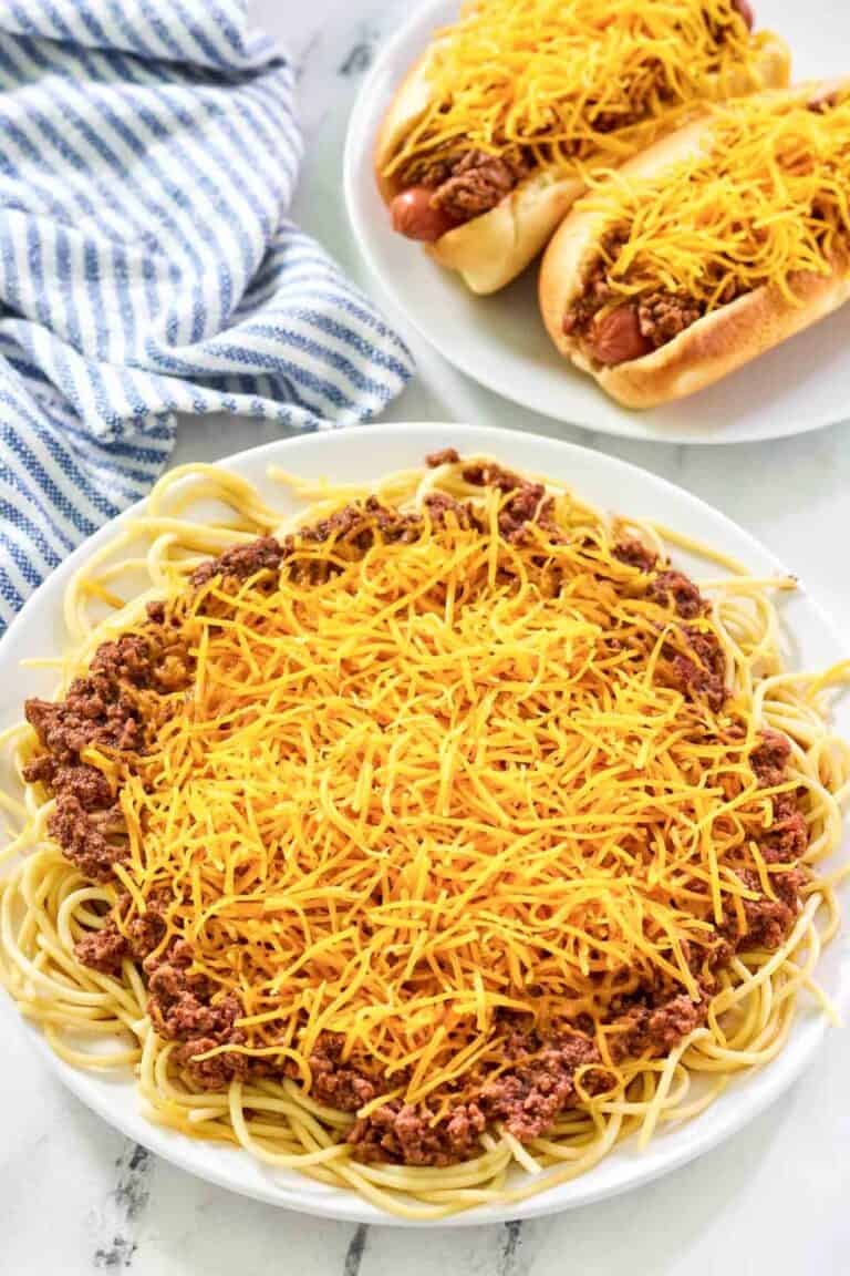 Spaghetti and hot dogs topped with chili and cheese.