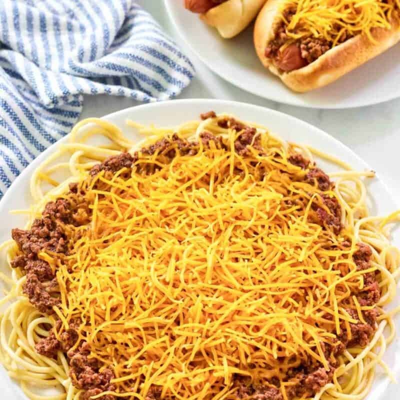 Spaghetti and hot dogs topped with chili and cheese.