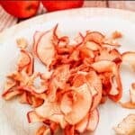 Air fryer apple chips piled on a plate.