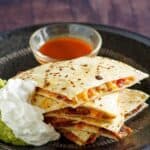 Copycat Applebee's bacon quesadilla served with guacamole, sour cream, and salsa.