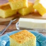 A slice of copycat Boston Market cornbread on a plate and butter behind it.