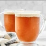 Copycat Harry Potter butterbeer in two glass mugs on a marble surface.