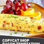 Copycat IHOP bacon temptation omelette and fruit on a plate.