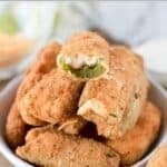 Crispy deep fried jalapeƱo poppers made with cheddar and cream cheese in a bowl.