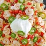 Copycat Red Lobster shrimp nachos with tomatoes, jalapeños, queso, and sour cream.
