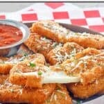 Copycat TGI Friday's fried mozzarella sticks and one pulled apart.