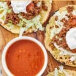 Copycat Taco Bell fire sauce in a bowl next to beef tostadas.