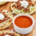 A small bowl of copycat Taco Bell fire sauce on a platter with tostadas.