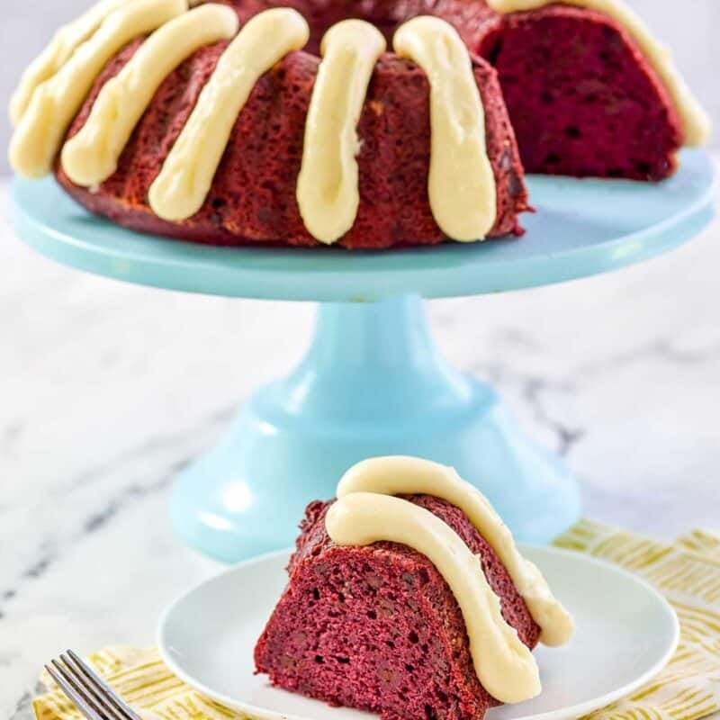 A bundt cake that's red velvet chocolate chip with piped cream cheese frosting.