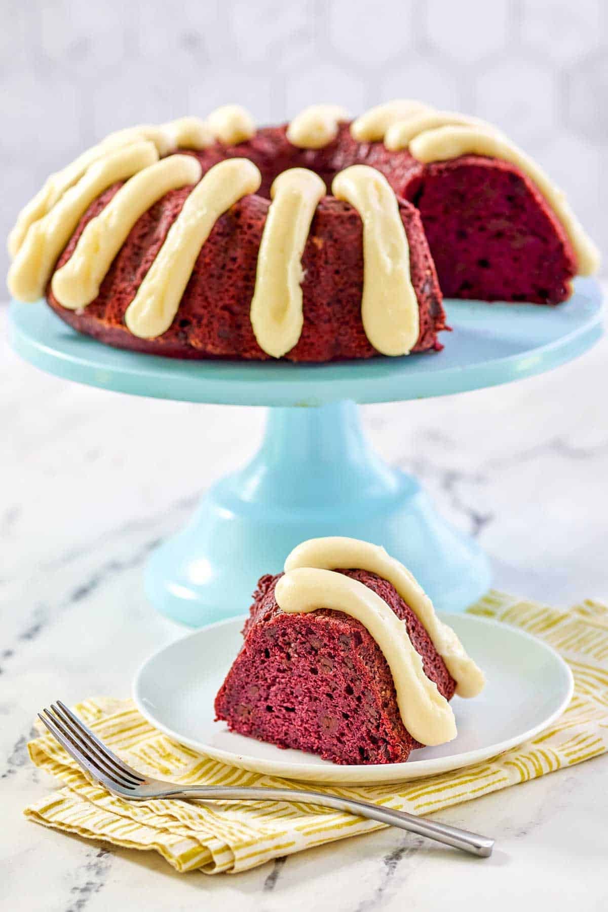 A bundt cake that's red velvet chocolate chip with piped cream cheese frosting.