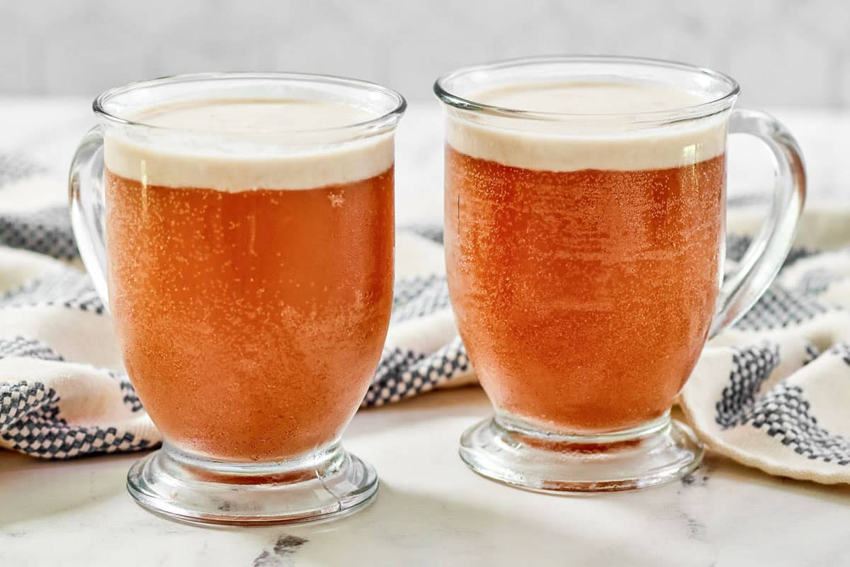 Two glasses of a butterscotch soda drink.