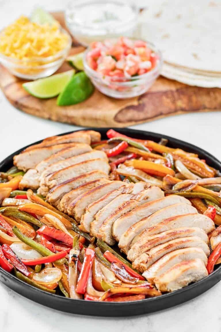 Fajitas with chicken and veggies served with tortillas, cheese, sour cream, and pico de gallo.