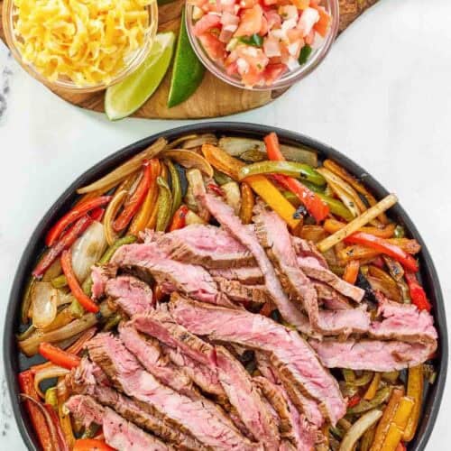 Fajitas with steak and veggies served with tortillas, cheese, pico de gallo, and sour cream.