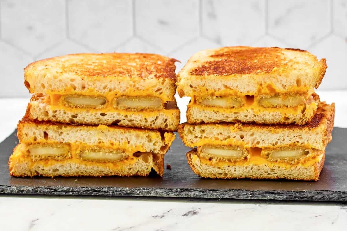 Grilled cheese made with fried cheese sticks on a platter.