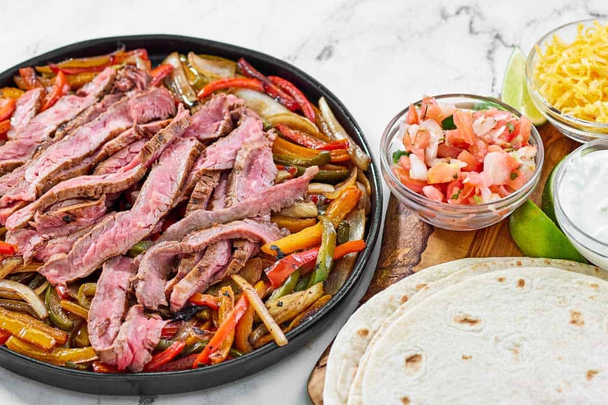 Grilled steak, bell peppers, and onions served with tortillas, pico de gallo, cheese, and sour cream.